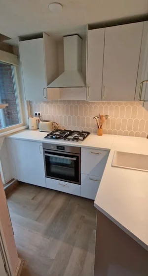 Afgewerkte keuken met spatwand en apparatuur